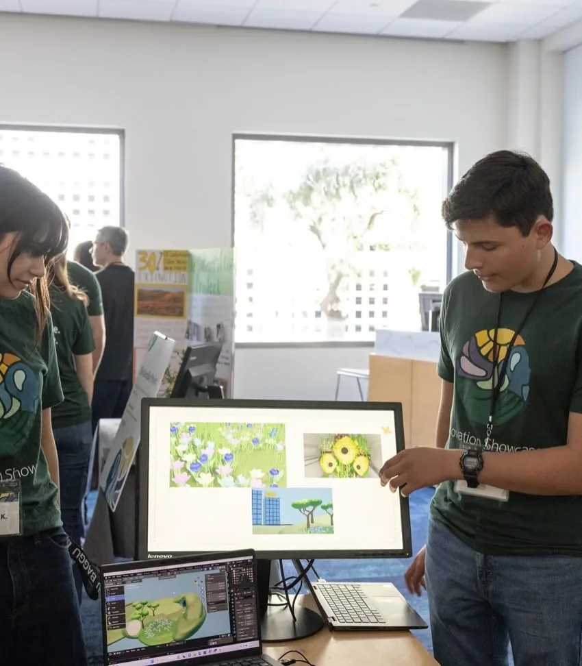 Students explain their digital design work at a showcase booth